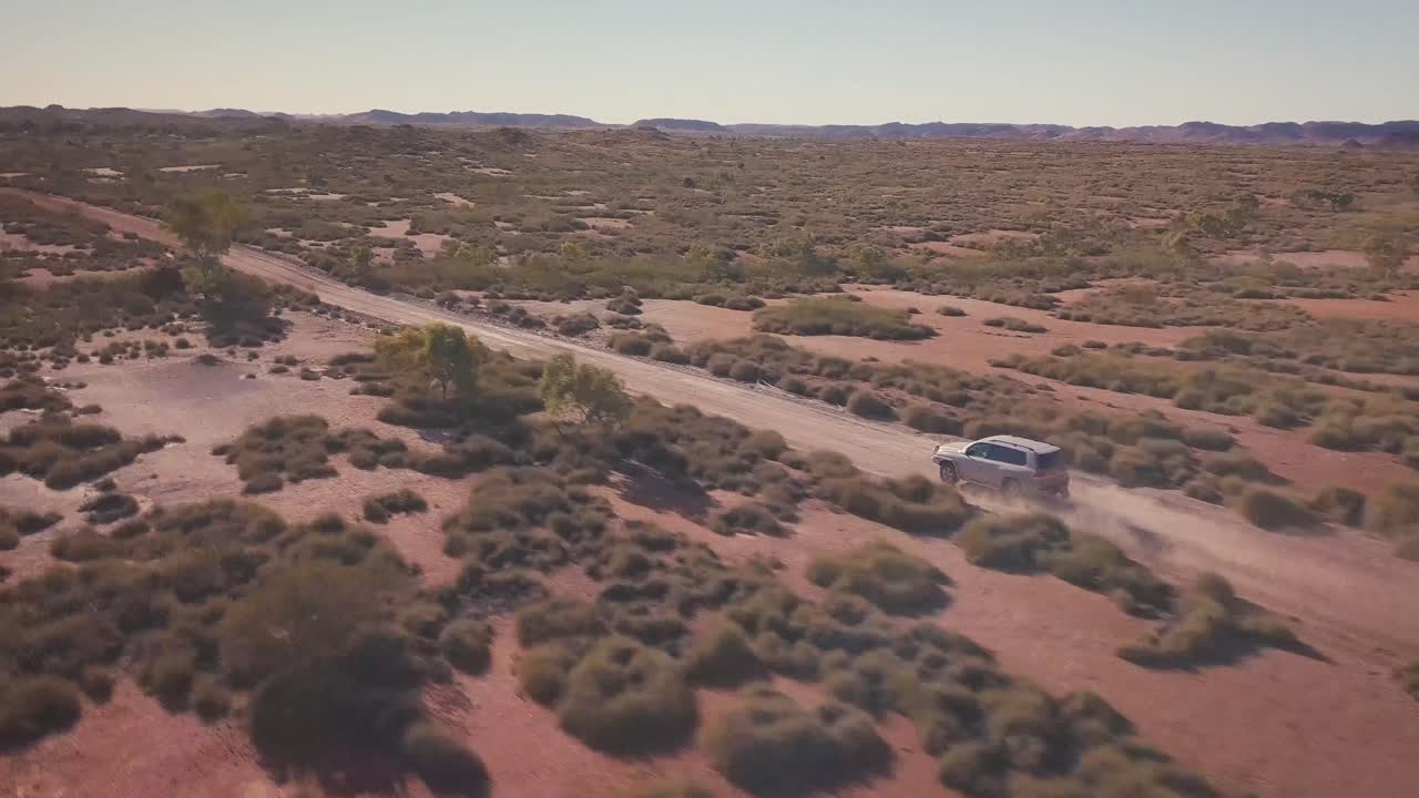 drone aéreo siguiendo un camino de ripio en 4x4 sobre el vasto desierto australiano