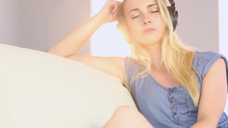hermosa adolescente relajándose en su sofá y escuchando música