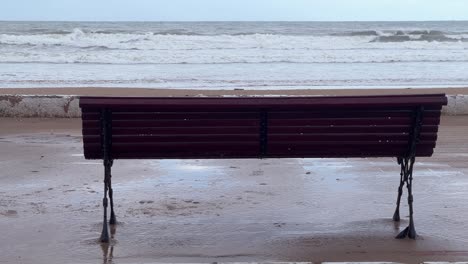 a solitary bench on the atlantic ocean promenade with crashing waves.