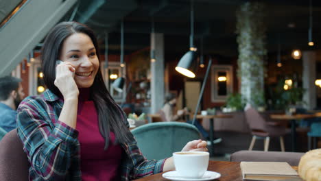 mujer hablando por teléfono en un café