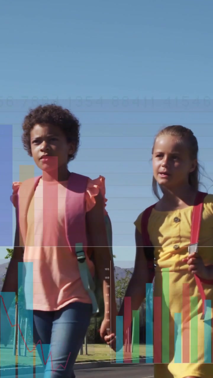 Vertical video: Girls walking hand-in-hand toward camera zooming, charts over backpacks for school