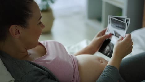 tracking right video of pregnant woman browsing ultrasound images.