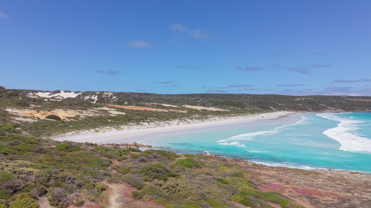 Ripresa drone delle onde blu intenso dell'Oceano Meridionale che si infrangono su una spiaggia sabbiosa e rocciosa a Bremer Bay, Australia Occidentale