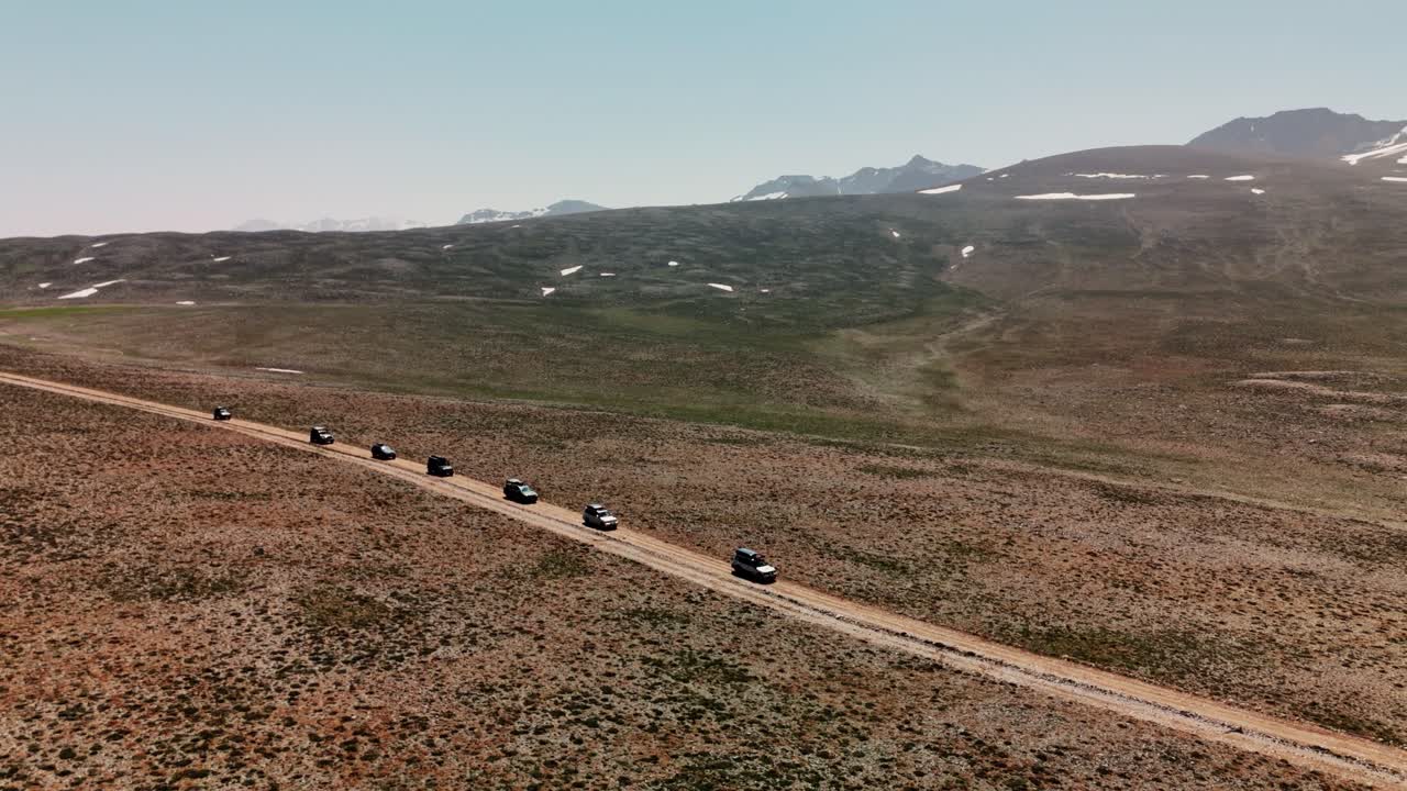 Aerial view of cars driving on dirt road in Cappadocia's vast landscape