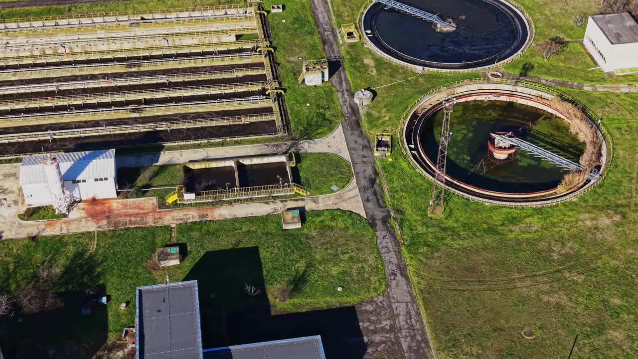 A water treatment facility is shown from above with large tanks and pipes