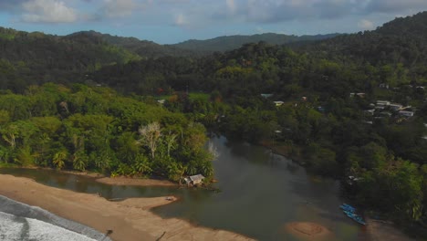 fishing boats alongside this epic north coast beach grande riviere as the river flows from the rainforest into the sea on the caribbean island of trinidad