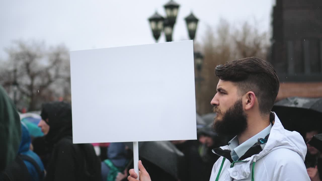 hombre durante la lluvia con un panel de cartel publicitario de maqueta vacío para el logotipo del anuncio.