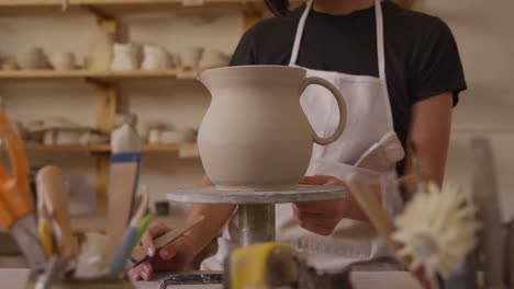 young female potter working in her studio