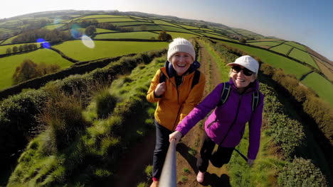 women hiking and taking selfies on a scenic country path
