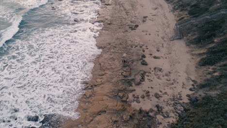 Family-on-remote-beach-birds-eye-view-pulling-away-aerial