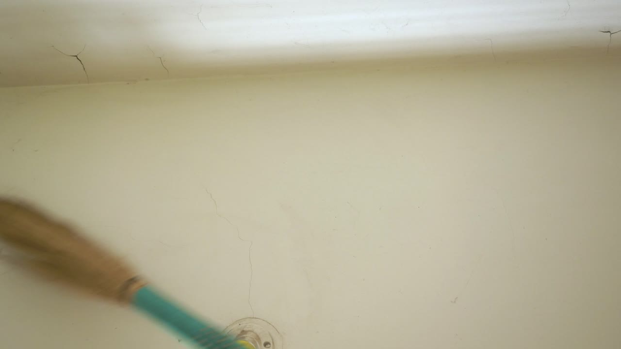 un hombre del sur de asia limpiando la pared de la casa antes de que comience la temporada de festivales