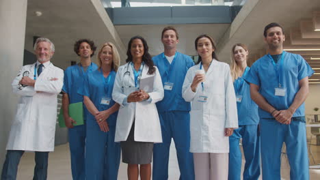 Portrait-Of-Multi-Cultural-Medical-Team-Wearing-Uniform-Standing-Inside-Hospital-Building