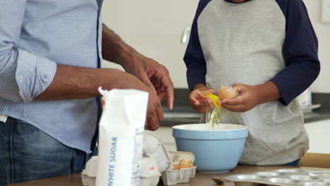 padre e hijo horneando pasteles en la cocina juntos