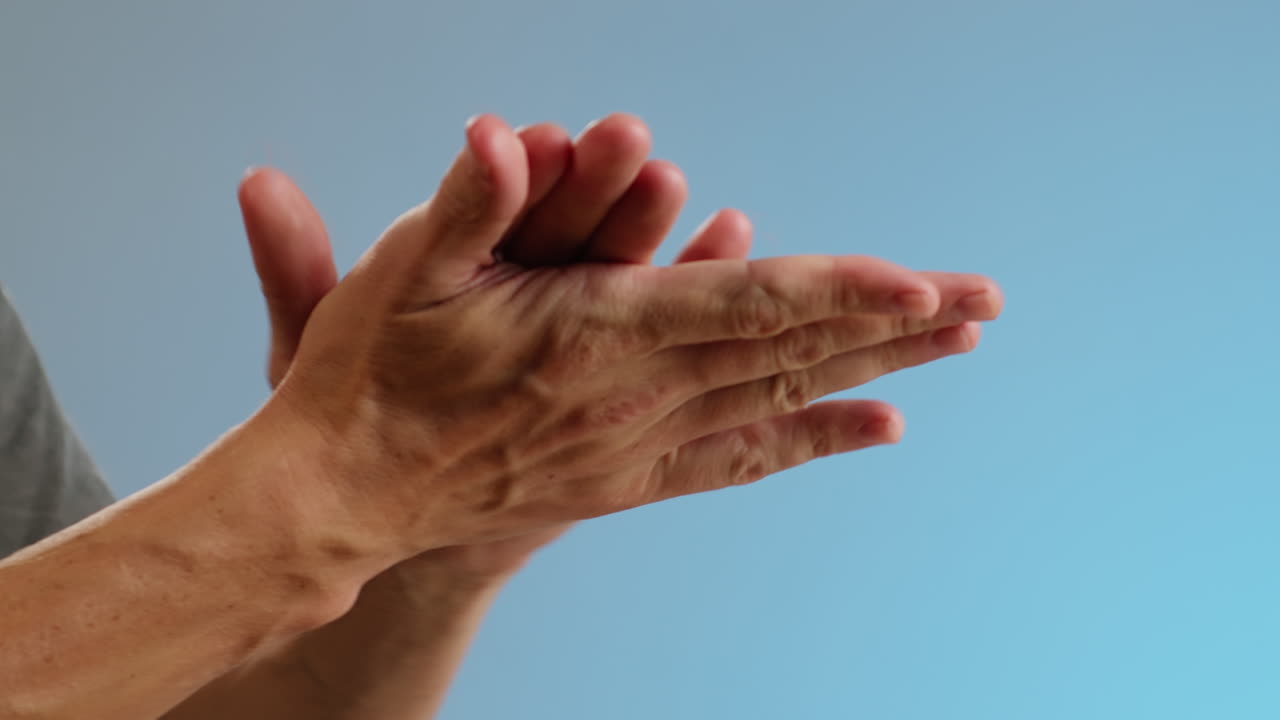 Young man squeezing a pink gel moisturizer oil from a tube on his hand close-up. Washing hands with antiseptic.Morning routine. Beauty and care concept. Skin texture.