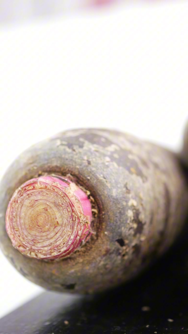 Close-up of Fresh Purple Carrots Rotating on White Background