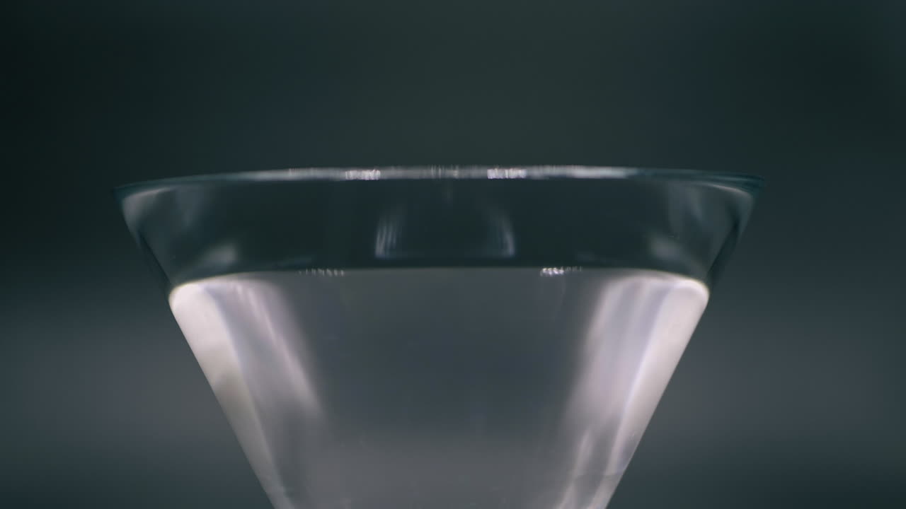 Red And Yellow Bell Peppers Dropping To A Glass Spilling The Water Out In Slow Motion - Closeup Shot