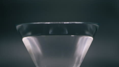 red and yellow bell peppers dropping to a glass spilling the water out in slow motion - closeup shot