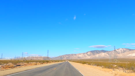 Conduciendo-Por-El-Desierto-De-Mojave-En-Un-Día-Caluroso-Y-Seco-Con-Un-Cielo-Azul-Claro---Punto-De-Vista-Del-Conductor