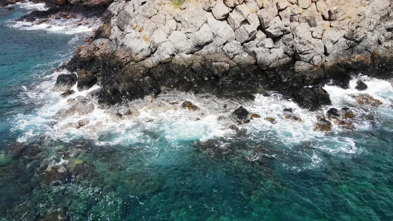 Onde che si infrangono sugli scogli lungo la costa a Maui, Hawaii.