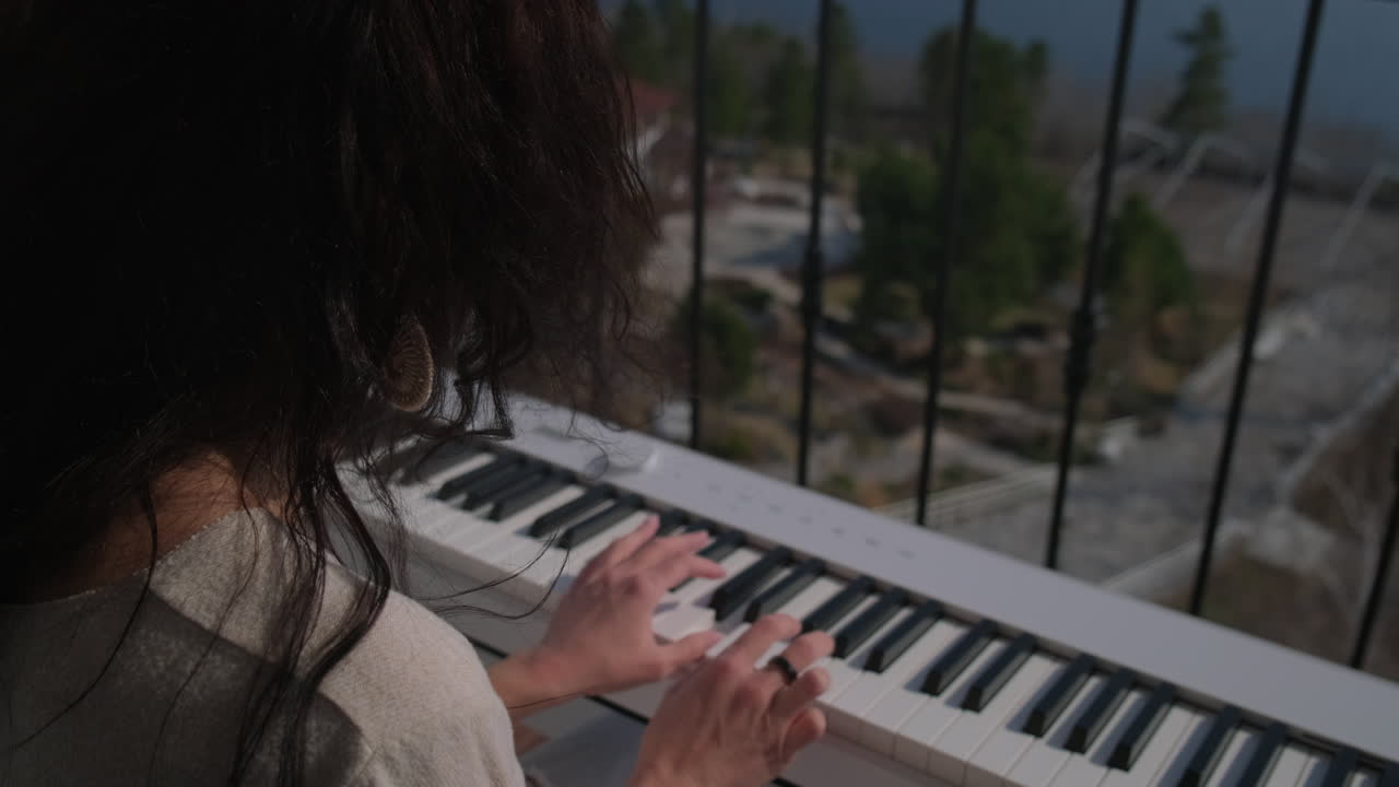 mujer tocando el piano en un balcón con una vista