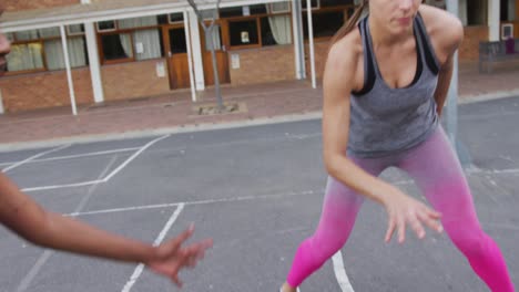 Diverse-female-basketball-team-playing-match,-dribbling-ball