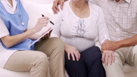 senior couple talking to nurse