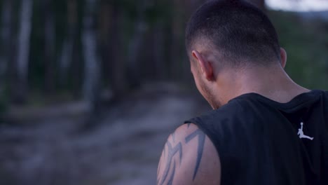 hombre con tatuaje en el bosque