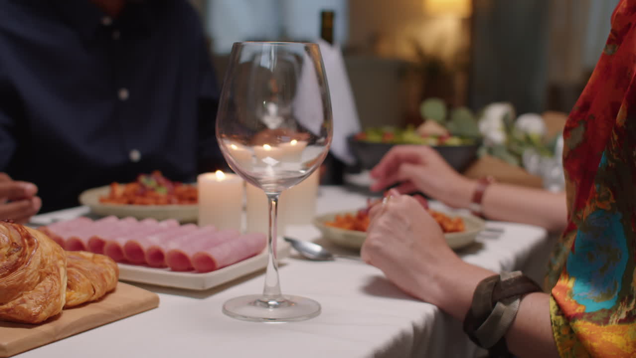 Hands of Man Pouring Wine into Glass of Wife at Table, Celebrating February 14th