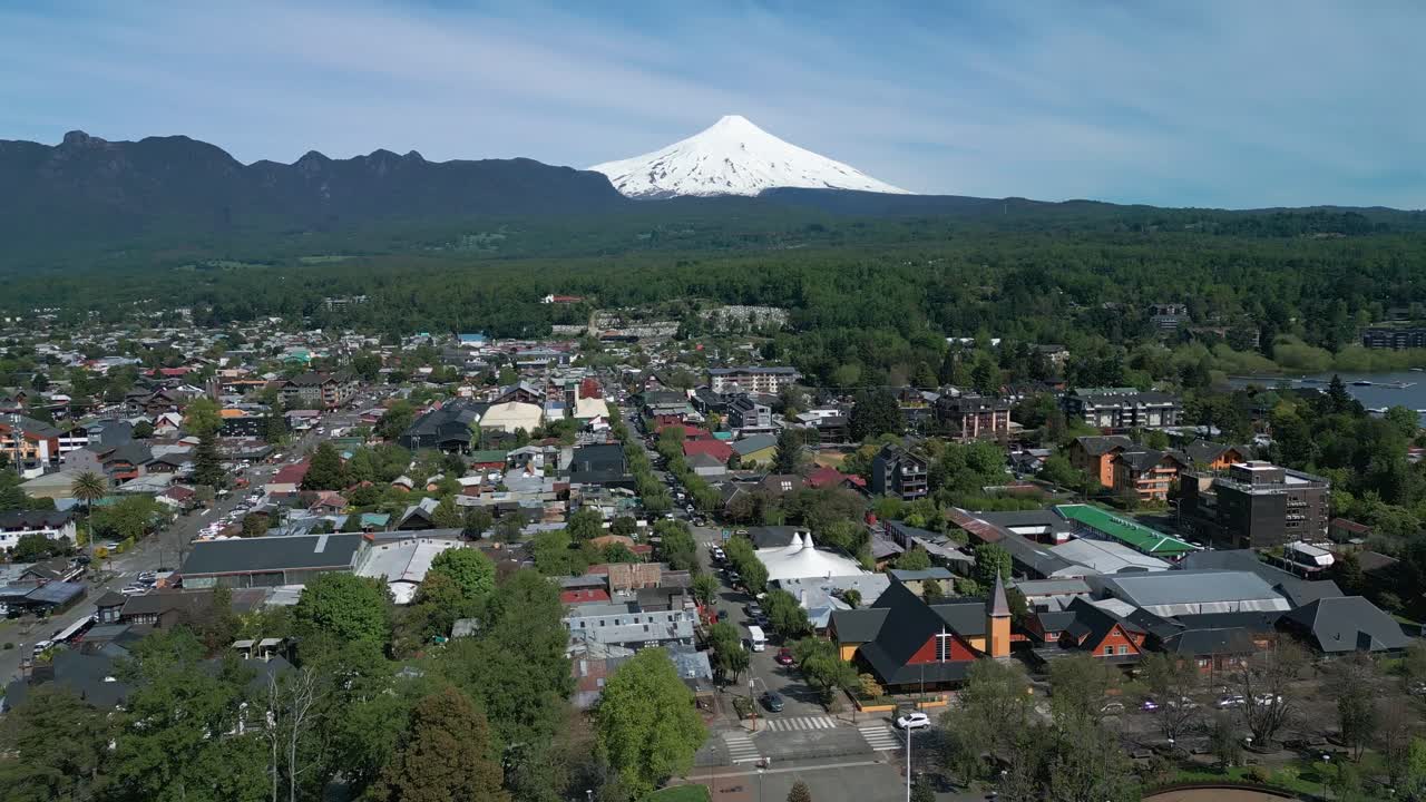 Flying above Pucon's town center, revealing Villarrica volcano and surrounding landscape on a clear day