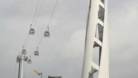 wide shot of public transport cable car air gondola crossing overhead between support towers