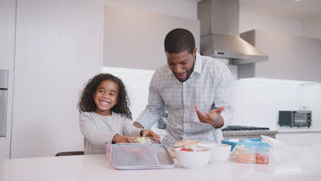 Father-And-Daughter-In-Kitchen-At-Home-Making-Healthy-Packed-Lunch-Together