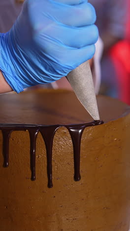 decoration of cake with liquid chocolate. melted chocolate flowing down from cake. close up. vertical video