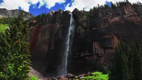 telluride bridal veil falls aerial drone waterfall telluride windy mist spray black bear pass road colorado pine tree ouray ridgway box canyon cliffside 4wd hiking cloudy sun blue sky upwards jib