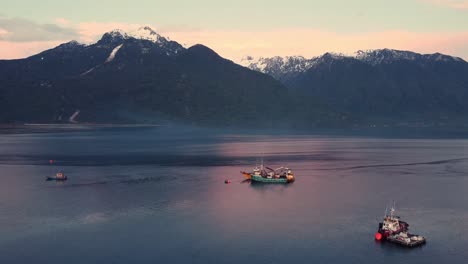 patagonia chilena, montañas nevadas adornan el lago y barcos pescando