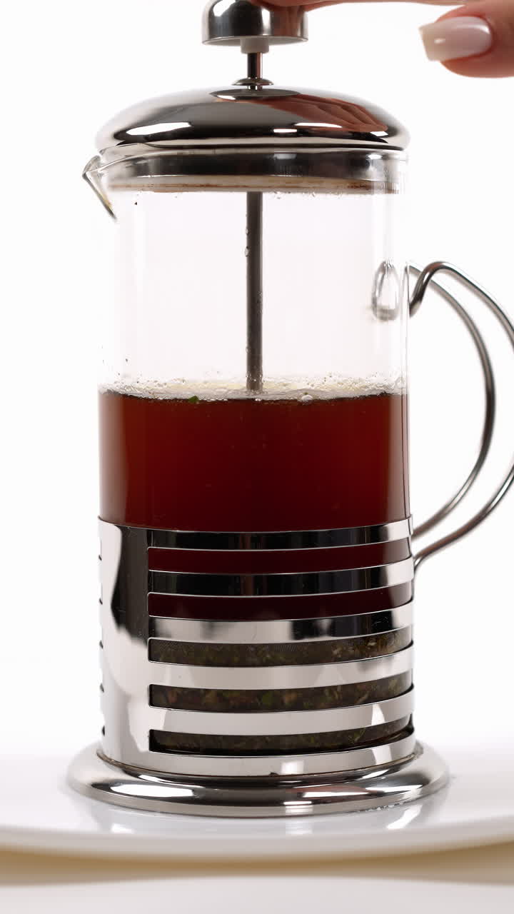 접시 위에 프랑스 프레스에서 차 주입, 플런저가 절반으로 압축