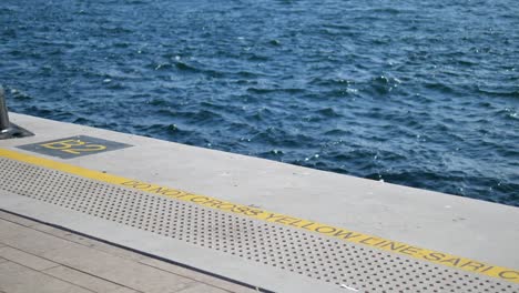 train platform with water view and warning sign