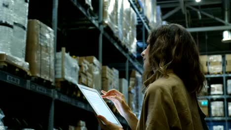 hermosa mujer con una tableta de computadora pc en busca de un producto en una sala de almacenamiento