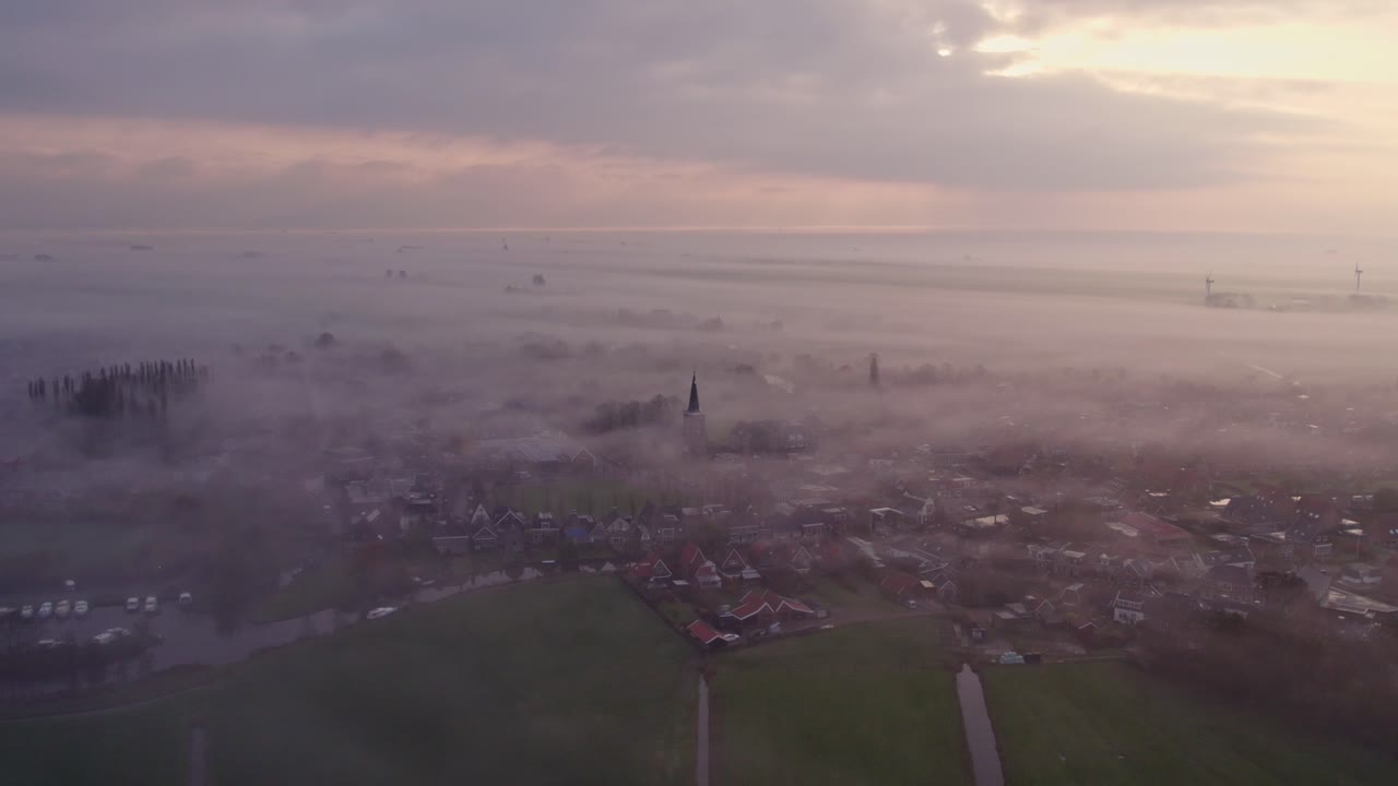 Kostel v Burgwerdu za úsvitu, zahalený v mlze, jemně září při východu slunce.