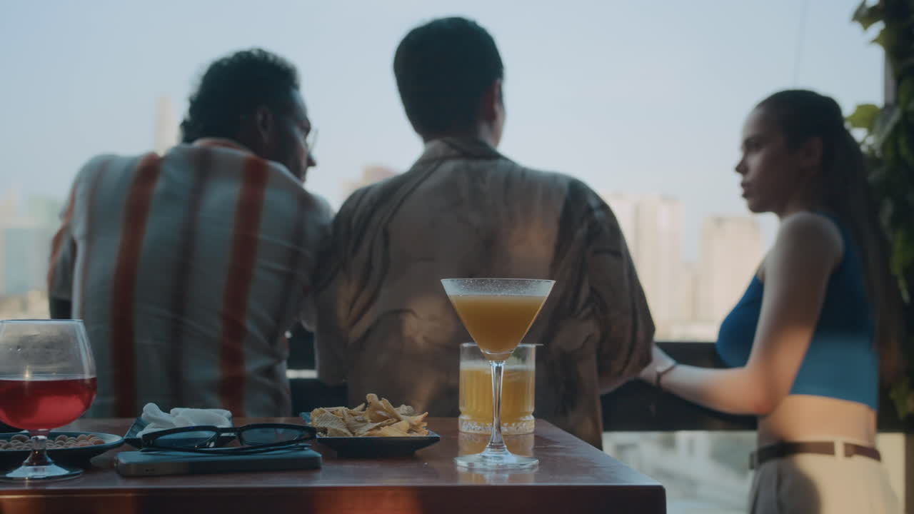 Three People Enjoying City View from panoramic Window in Bar