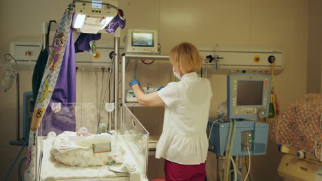 nurse caring for newborn in neonatal intensive care unit