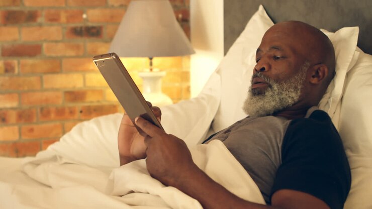 Ældre mand bruger tablet i soveværelset 4K