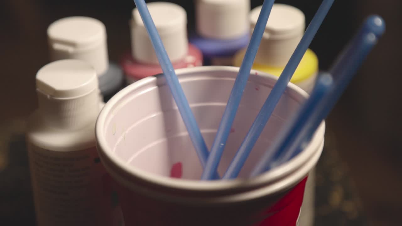 Colorful Oil Paints And Used Paintbrushes Inside The Plastic Red Cup.- closeup shot