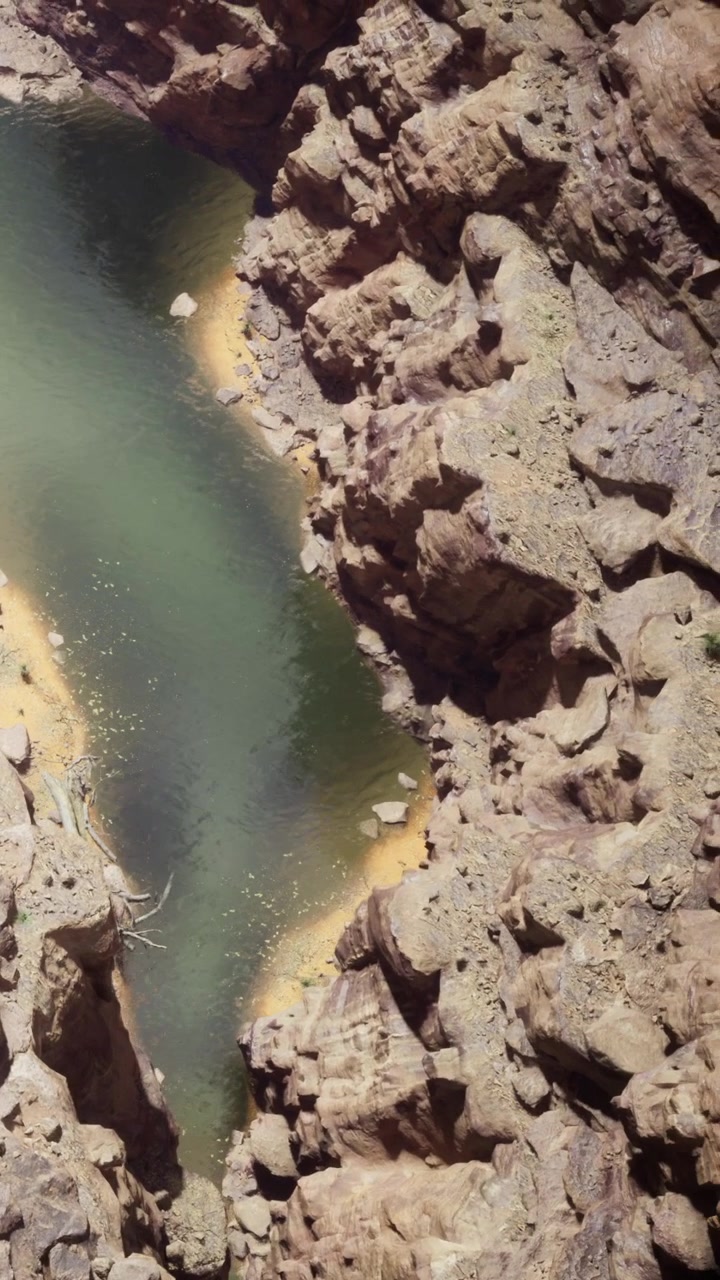 Paesaggio roccioso con un fiume serpeggiante sotto la luce del sole all'aperto