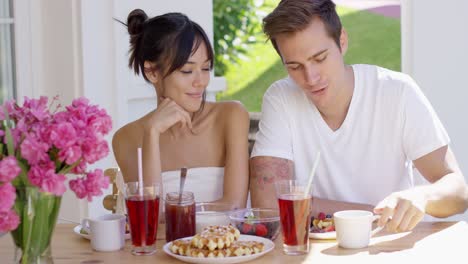 Attractive-couple-enjoying-breakfast-outdoors