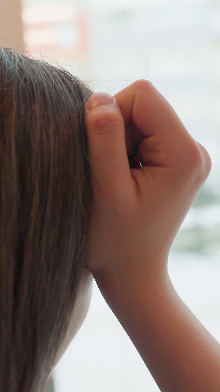 젊은 여성이 머리에 손을 얹고 눈 덮인 도시 풍경을 창밖으로 바라보고 있어요. 손가락은 관자놀이 근처에서 꽉 쥐어져 있고, 테이블 위에는 청록색 컵이 놓여 있어요. 스웨터 소매가 보이는 구도는 그리움, 기다림, 겨울의 분위기를 전달하네요.