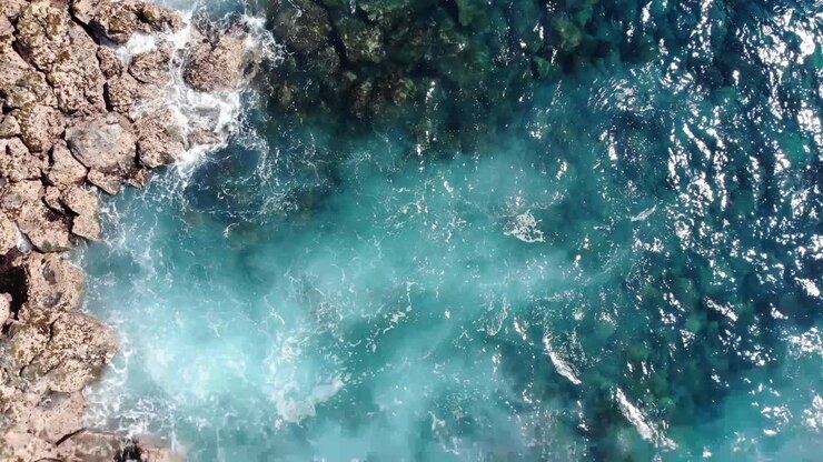 schiuma dalle onde del pacifico che incontrano le coste vulcaniche rocciose dell'isola delle hawaii