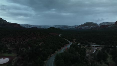 Carretera-Con-Vehículos-Que-Viajan-En-Sedona,-Arizona-En-Una-Puesta-De-Sol-Nublada---Toma-Aérea-De-Drones