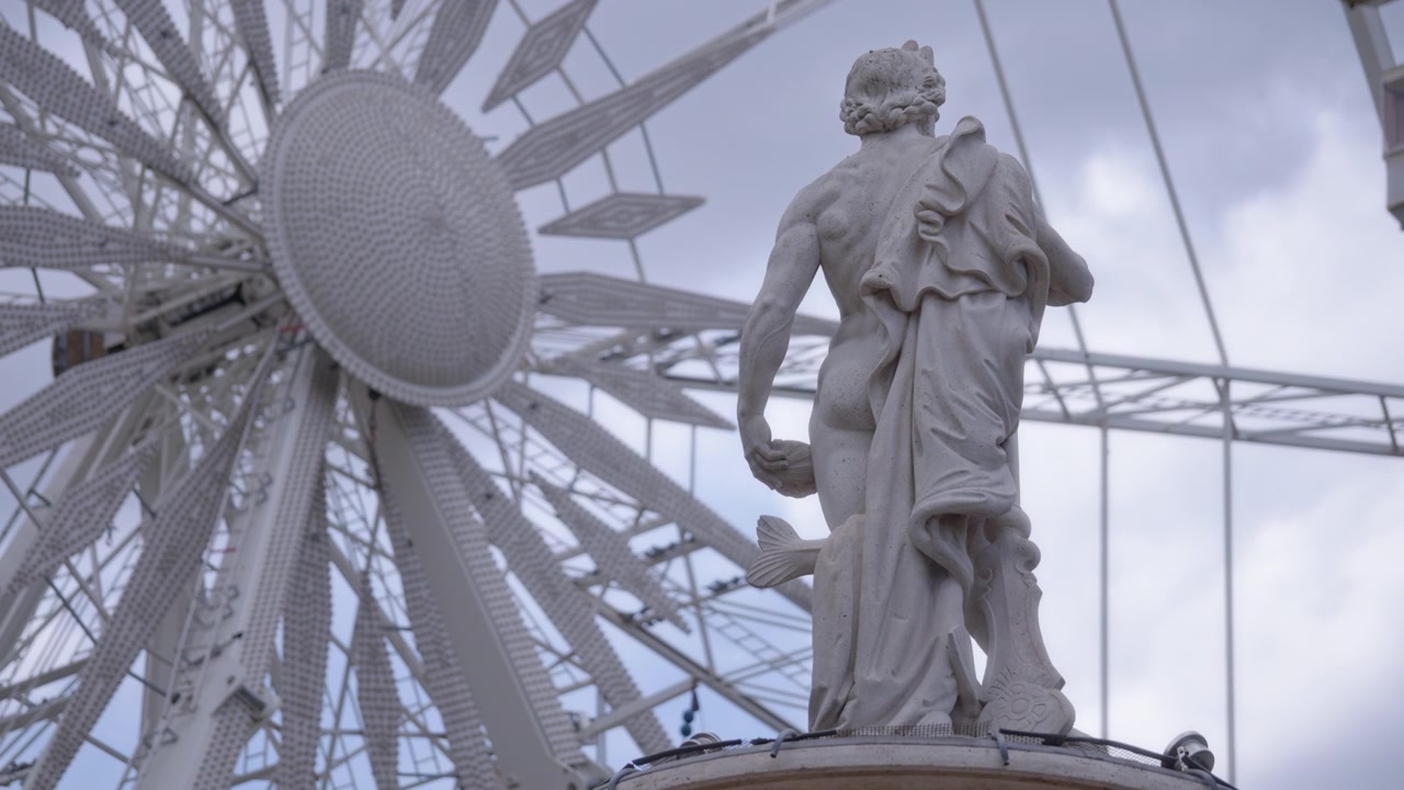 Statua maschile e ruota panoramica girevole