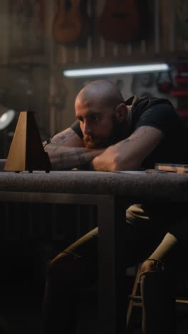 man working in a music instrument repair shop