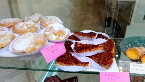 postres tradicionales de aveiro exhibidos en un mostrador con etiquetas que muestran sus nombres y precios, portugal